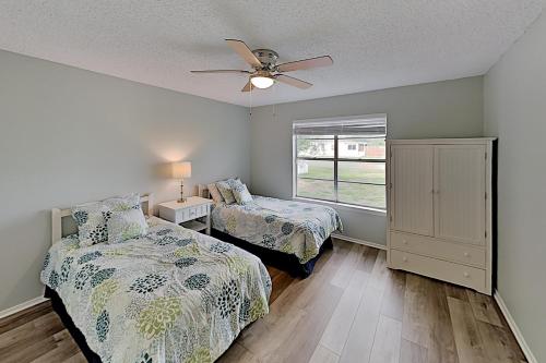 a bedroom with two beds and a ceiling fan at Rockport Beach Club East & West in Rockport