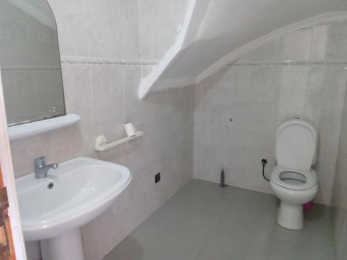 ein weißes Bad mit einem Waschbecken und einem WC in der Unterkunft Chez Mostafa in Douar Ourlali