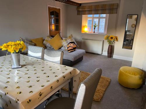 a living room with a table and a couch at Yew Tree Cottage, 3 bedroom, 4 Church Row Defynnog in Devynock