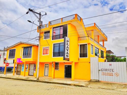 a yellow building on the side of a street at HOTEL PLAYAS PERDERNALES ECUADOR in Pedernales