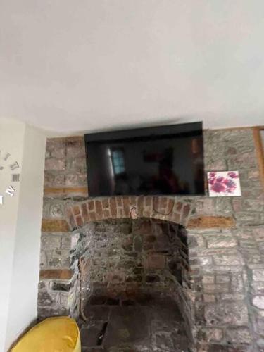 a stone fireplace with a tv on top of it at Yew Tree Cottage, 3 bedroom, 4 Church Row Defynnog in Devynock