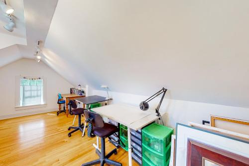 una oficina en el ático con escritorio y sillas en Full of Light Cottage, en Rockland