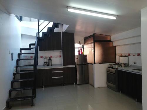 eine Küche mit einer Treppe in der Mitte eines Zimmers in der Unterkunft Casa valicha ejecutivo in Cusco