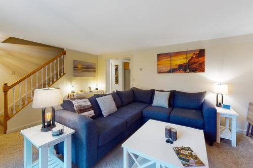 a living room with a blue couch and two tables at Bampi's Dream in East Lamoine