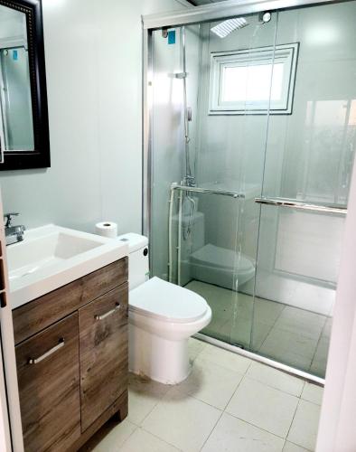 a bathroom with a toilet and a glass shower at Independent guest unit with separate entry in Chilliwack