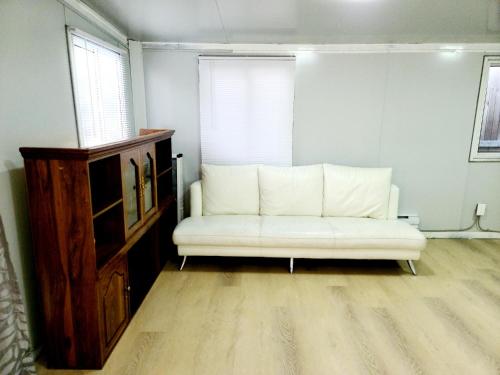- un canapé blanc dans une pièce avec fenêtre dans l'établissement Independent guest unit with separate entry, à Chilliwack