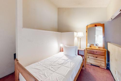 a small bedroom with a bed and a mirror at Crestview 70 in Mammoth Lakes