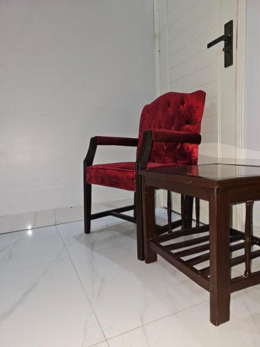 une chaise rouge assise à côté d'une table en bois dans l'établissement Hotel Continental lnn Karachi, à Karachi