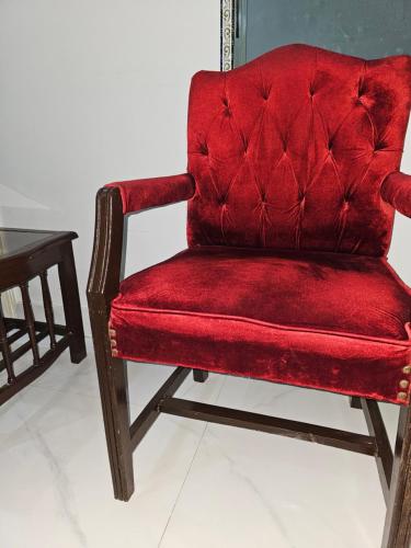 une chaise rouge assise à côté d'une table dans l'établissement Hotel Continental lnn Karachi, à Karachi