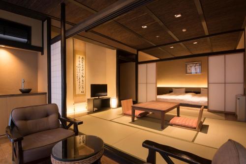 uma sala com um quarto com uma cama e uma mesa em Matsuzakaya Honten em Hakone