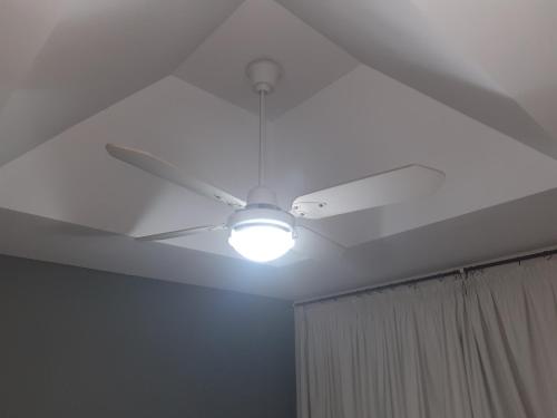 a ceiling fan with a light in a room at Departamento temporal Mariano in Santa Rosa