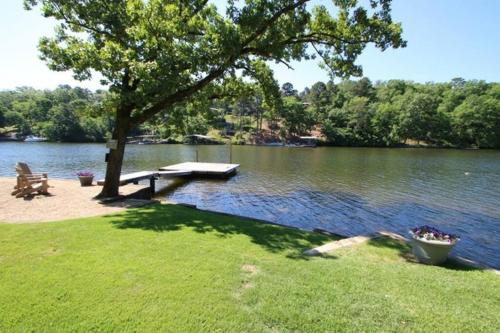 a lake with a picnic table and a tree and a bench at #02 - Unique Lakeside Studio Cottage- Pet Friendly in Hot Springs