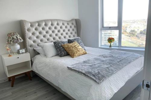 a bedroom with a bed with a tufted headboard at Downtown 3br/2ba+Views+Skytrain+Free Parking in Vancouver