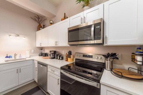 a kitchen with white cabinets and a microwave at Renovated 2 bed 2 bath Near Arena and Downtown in Spokane