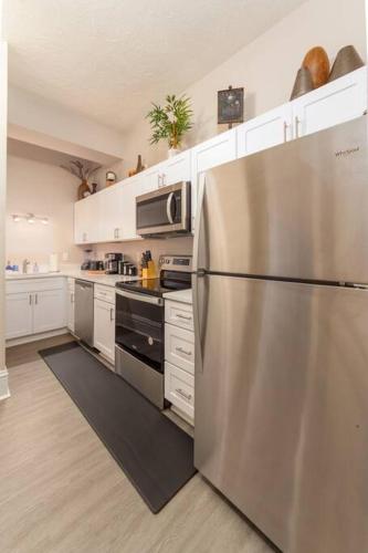 a kitchen with a stainless steel refrigerator and white cabinets at Renovated 2 bed 2 bath Near Arena and Downtown in Spokane
