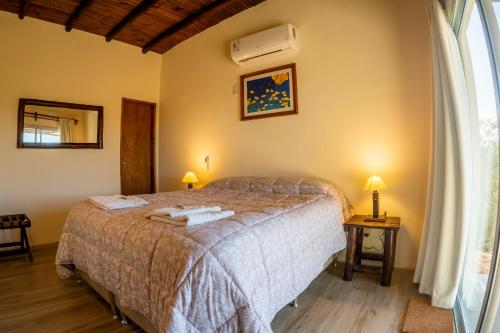 a bedroom with a bed with two towels on it at Chacra Roxy in El Eden