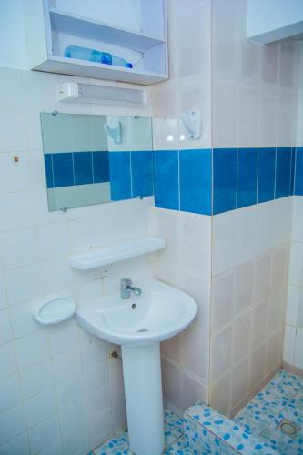a bathroom with a sink and a mirror at Appartements madame lydie in Pointe-Noire