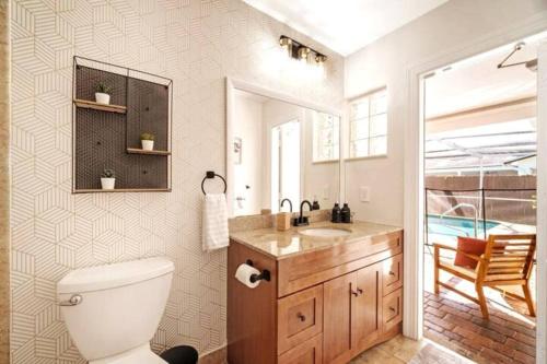 uma casa de banho com um WC, um lavatório e um espelho. em Secluded Oasis with Private Pool, The Ultimate Relaxation! em Sunrise