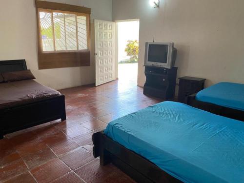 a bedroom with two beds and a tv in it at Finca Esperanza - Girardot - El Espinal in El Espinal