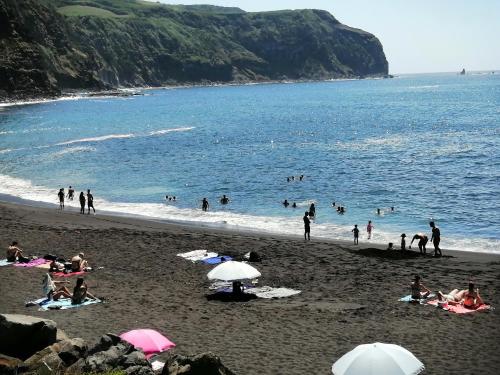 a group of people on a beach near the water at Casa Dos Mosteiros in Mosteiros