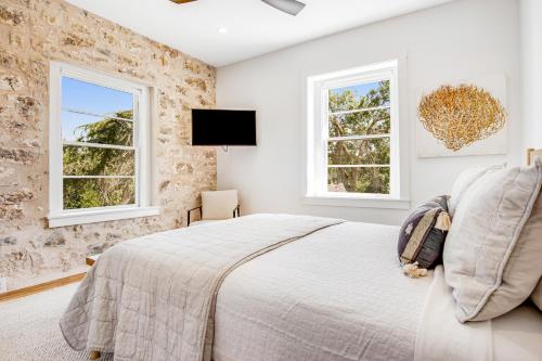 een slaapkamer met een bed en twee ramen bij Fredericksburg Mill in Fredericksburg