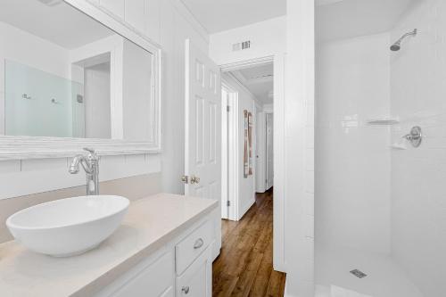 a white bathroom with a sink and a mirror at Newport Coastal Compound in Newport Beach