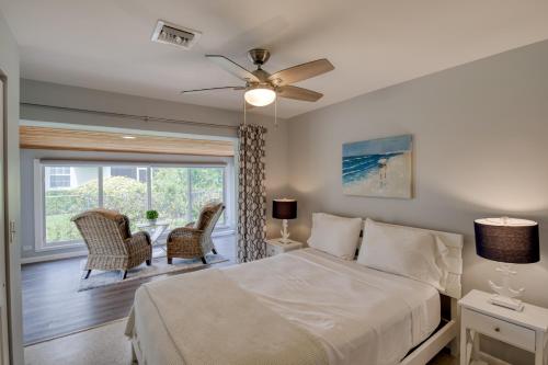 een slaapkamer met een bed en twee stoelen en een raam bij Coconut Grove Singer Island - Units 1, 3, & 4 in Riviera Beach