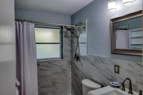 een badkamer met douche, wastafel en raam bij Coconut Grove Singer Island - Units 1, 3, & 4 in Riviera Beach