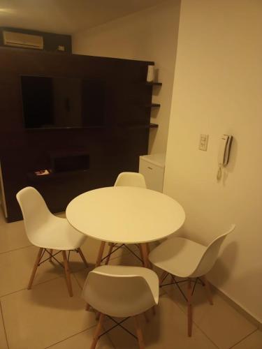 a white table and chairs in a room with a tv at Monoambiente San Isidro in San Juan