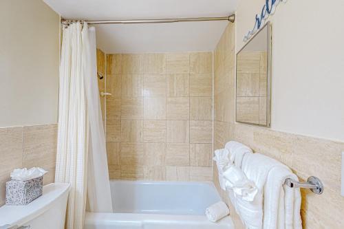 ein Badezimmer mit einer weißen Badewanne und einer Dusche in der Unterkunft The Blue Heron, Unit 312 in Satellite Beach