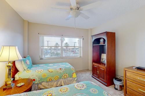 1 Schlafzimmer mit 2 Betten und einem Deckenventilator in der Unterkunft The Blue Heron, Unit 312 in Satellite Beach