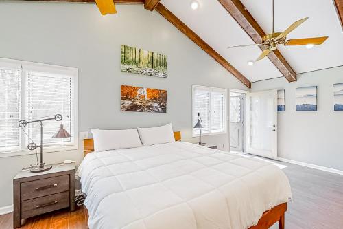 a white bedroom with a large bed and a ceiling fan at Smoky Mountain Estate in Sevierville