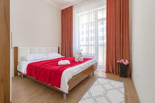 1 dormitorio con 1 cama con manta roja en Expo Residentce Кабанбай Батыра 60А, 