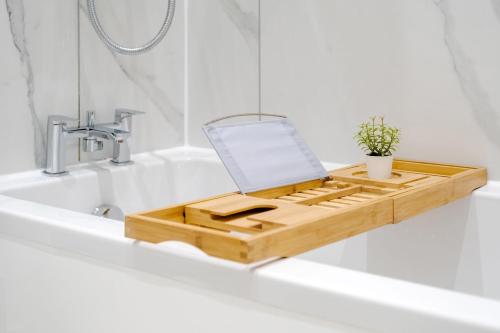 a wooden tray sitting on top of a bathroom sink at Urban Luxury 4-Bed Retreat Explore And Relax in London