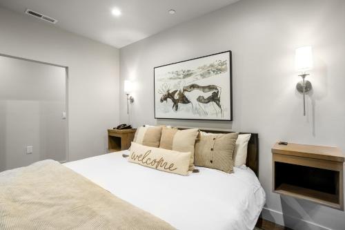 um quarto branco com uma cama grande e uma imagem na parede em Lion Square Lodge South 255, 257 & 261 em Vail