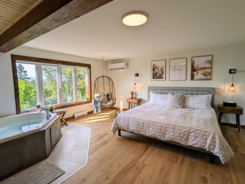 a bedroom with a bed and a bath tub at Summer in Tremblant and Mont Blanc, Views, Spa and Pool table in Saint-Faustin