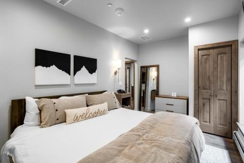 Un dormitorio con una gran cama blanca y una puerta en Lion Square Lodge South 257, en Vail