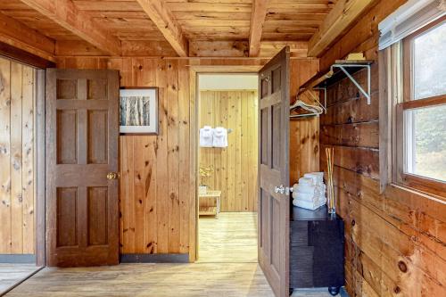 un pasillo en una cabaña de madera con puerta en Modern Log Chalet - Upper Level, en Montgomery