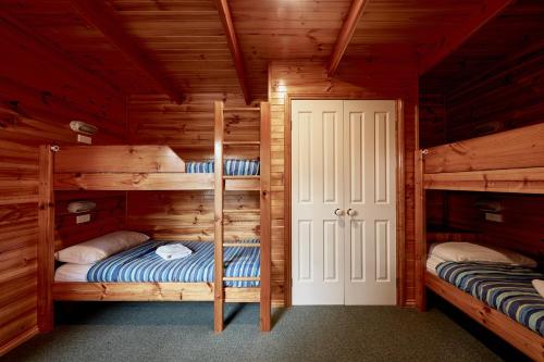 a bedroom with two bunk beds in a log cabin at Anglesea Family Caravan Park in Anglesea