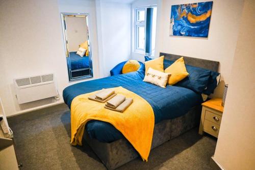 ein Schlafzimmer mit einem blauen Bett und einer gelben Decke in der Unterkunft Apartment in city centre Leicester in Leicester