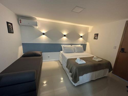 una piccola camera da letto con un letto e un divano di Audaar Tech Suítes - Aeroporto de Congonhas a San Paolo