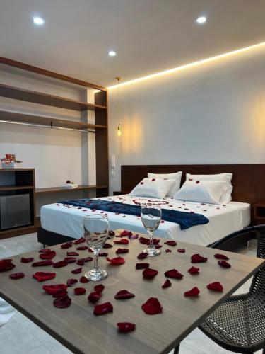Un dormitorio con una cama y una mesa con rosas. en Hotel el tamaco, en Ocaña