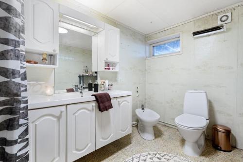 a white bathroom with a toilet and a sink at Cozy 130sqm house right above the city center. in Tromsø