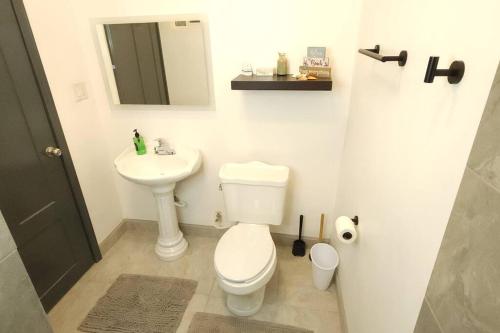 a bathroom with a white toilet and a sink at Stay Here! 10 MIN FROM BEACH! 2 bedroom house in Puerto Peñasco