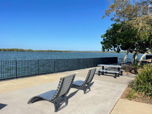 two chairs and a picnic table next to the water at Fisher River Front in Griffin