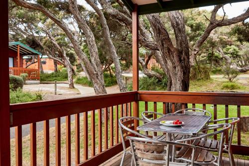 a table and chairs on a porch with a view of a yard at Anglesea Family Caravan Park in Anglesea