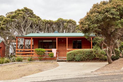 a wooden house with a green roof at Anglesea Family Caravan Park in Anglesea