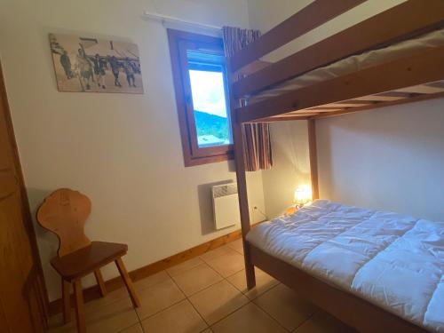 a bedroom with a bunk bed and a chair and a window at Appartement Samoëns, 3 pièces, 6 personnes - FR-1-624-12 in Samoëns