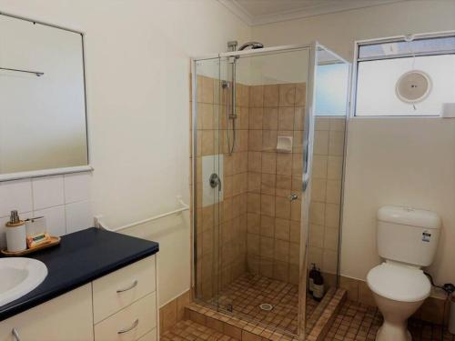 a bathroom with a shower with a toilet and a sink at Three Palms Apartments Unit 4 in Esperance