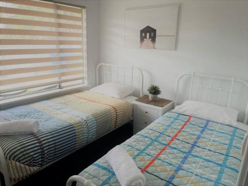 - une chambre avec 2 lits et une fenêtre dans l'établissement Three Palms Apartments Unit 4, à Esperance